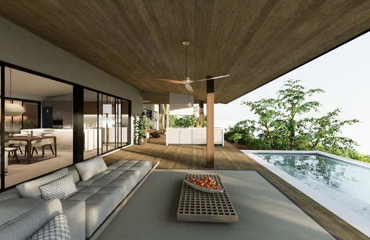 Un espacio de vida interior-exterior integrado, con una terraza de madera, una acogedora área de descanso con un sofá seccional gris y una pequeña piscina rodeada de exuberante vegetación. Puertas corredizas de vidrio conectan el lounge exterior con un mo